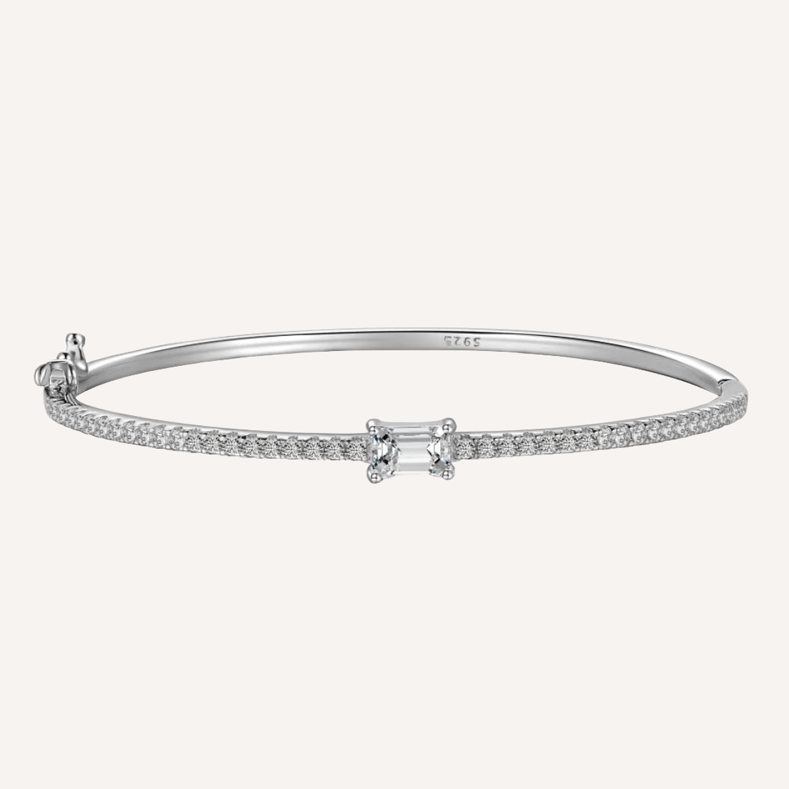 Schmaler feiner Armreif aus 925 Sterling Silber mit rhodium beschichtet. Der Armreif ist mit unzähligen kleinen zirconia Steinchen besetzt die wunderschön schimmern. In der Mitte ist ein großer Zirconia Stein angebracht mit elegantem Smaragdenschliff. Der Armreif ist mit 925 eingraviert als symbol von Qualität. Der Armreif ist ein hochwertiges Schmuck Geschenk für Frauen die zeitlose Eleganz und Langlebigkeit Schätzen.