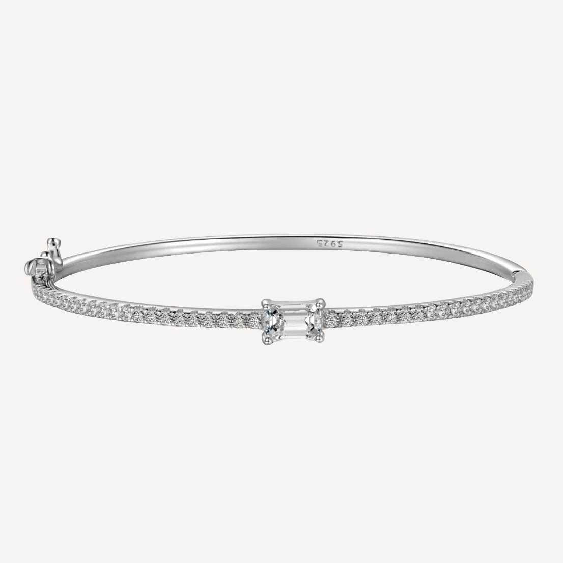 Schmaler feiner Armreif aus 925 Sterling Silber mit rhodium beschichtet. Der Armreif ist mit unzähligen kleinen zirconia Steinchen besetzt die wunderschön schimmern. In der Mitte ist ein großer Zirconia Stein angebracht mit elegantem Smaragdenschliff. Der Armreif ist mit 925 eingraviert als symbol von Qualität. Der Armreif ist ein hochwertiges Schmuck Geschenk für Frauen die zeitlose Eleganz und Langlebigkeit Schätzen.  