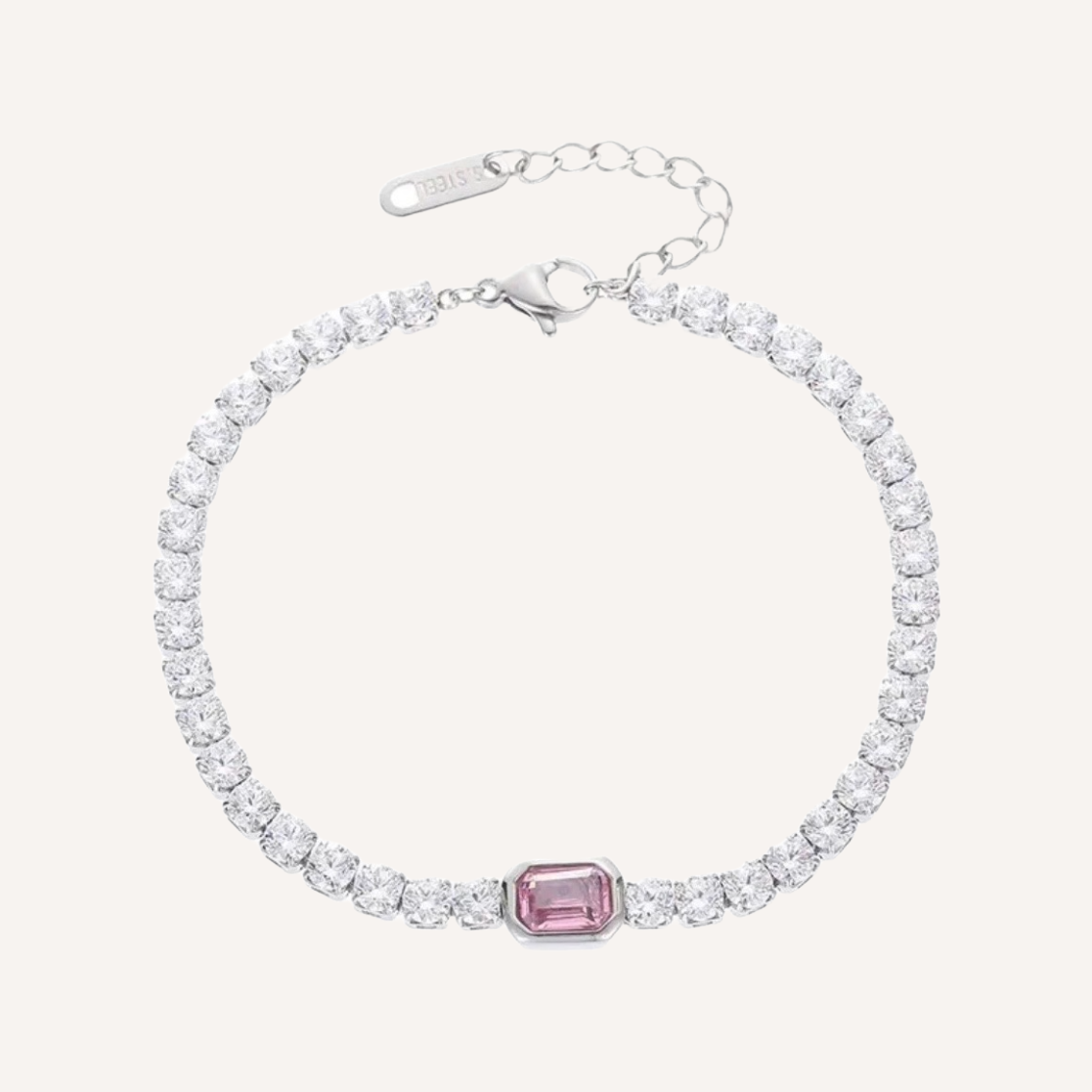 Ein Silber Tennisarmband mit runden Zirkonia steinen. Dr Hauptstein ist Rechteckig und ein rosa Zirkonia. Das Armband hat eine Verlängerungskette zur Verstellung der Größe, daran hängt ein Ovaler Anhänger der mit S.Steel eingraviert ist.