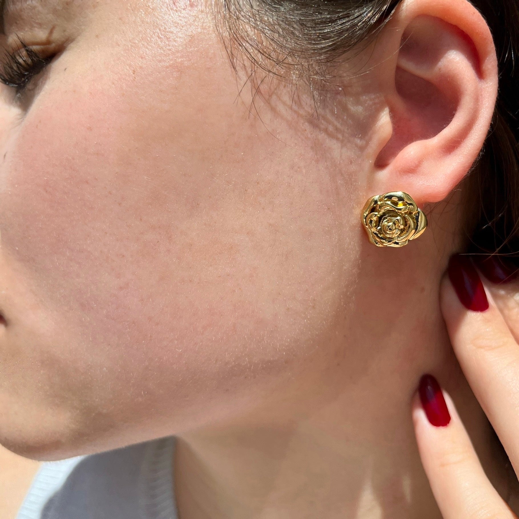 gold statement earrings shaped like a rose. the perfect gold statement piece worn by a woman